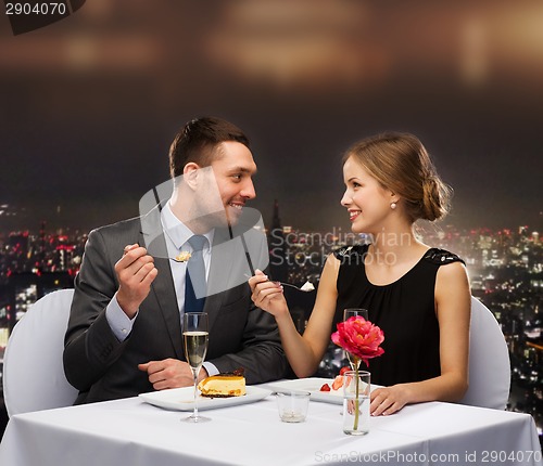 Image of smiling couple eating dessert at restaurant