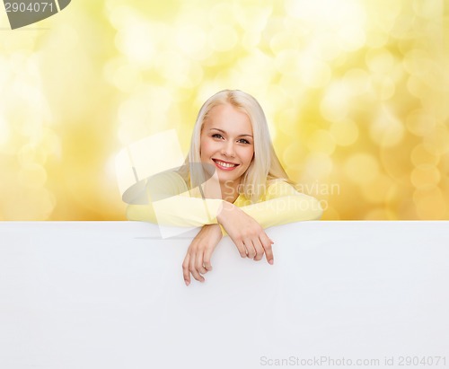 Image of smiling woman in sweater with blank white board