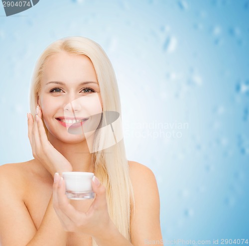 Image of woman applying cream on her skin