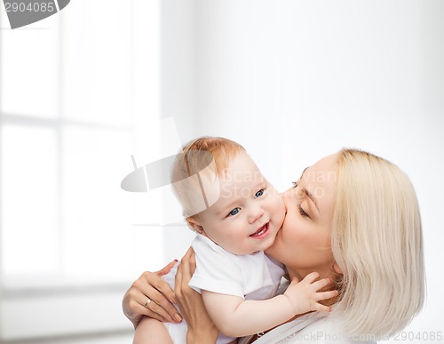 Image of happy mother kissing smiling baby