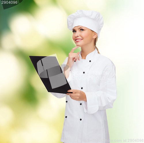 Image of smiling female chef with black blank paper