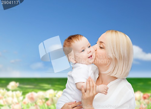 Image of happy mother kissing smiling baby