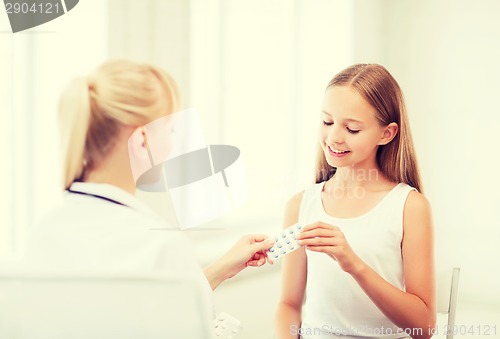 Image of doctor giving tablets to child in hospital