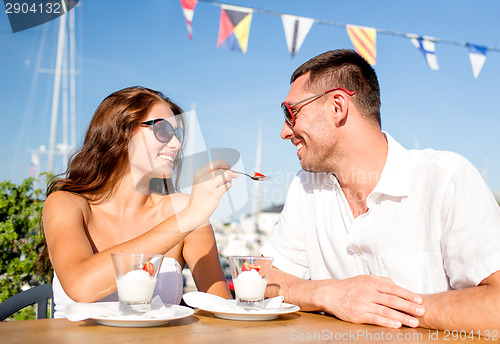 Image of smiling couple eating dessert at cafe