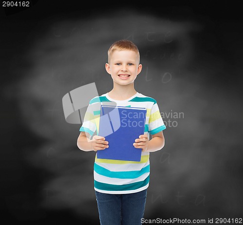 Image of smiling little student boy with blue book