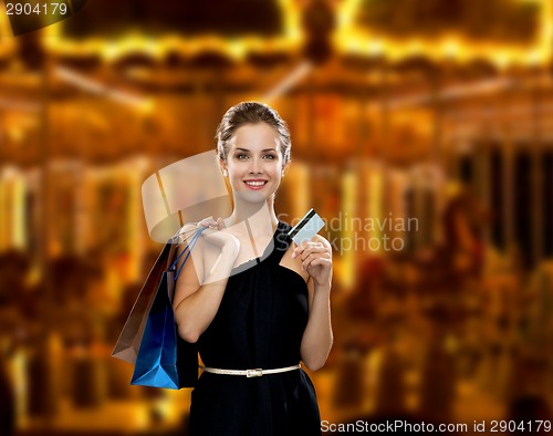 Image of smiling woman with shopping bags and credit card