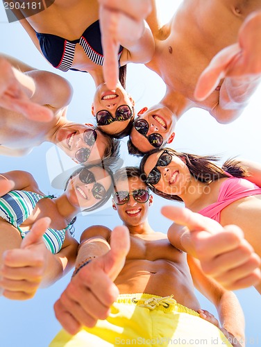 Image of smiling friends showing thumbs up in circle