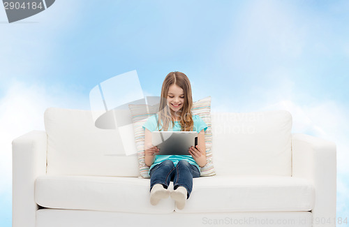 Image of little girl sitting on sofa with tablet pc