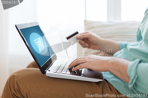 Image of close up of man with laptop and credit card