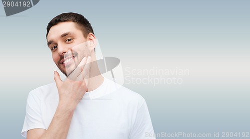 Image of beautiful smiling man touching his face