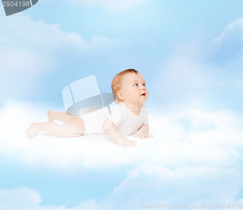 Image of smiling baby lying on cloud and looking up