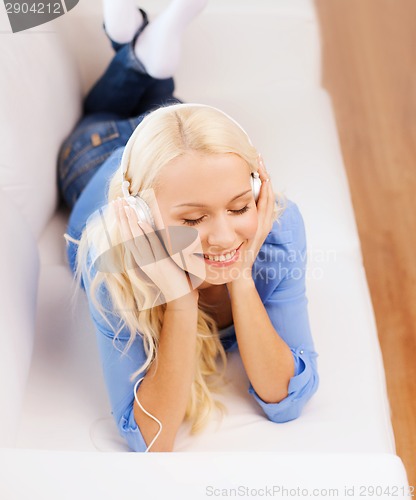 Image of smiling young woman in headphones at home
