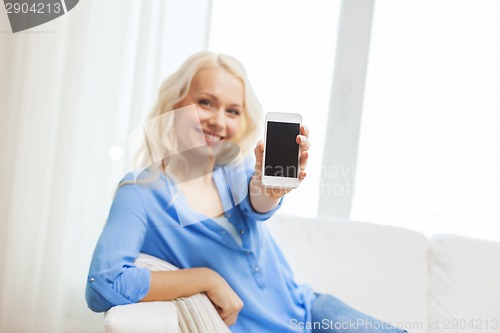 Image of smiling woman with smartphone at home