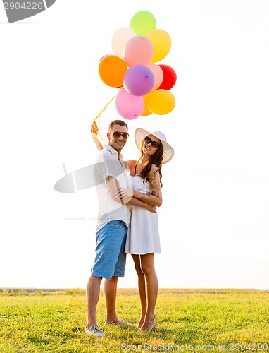 Image of smiling couple with air balloons outdoors