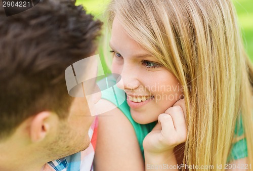 Image of smiling couple looking at each other in park