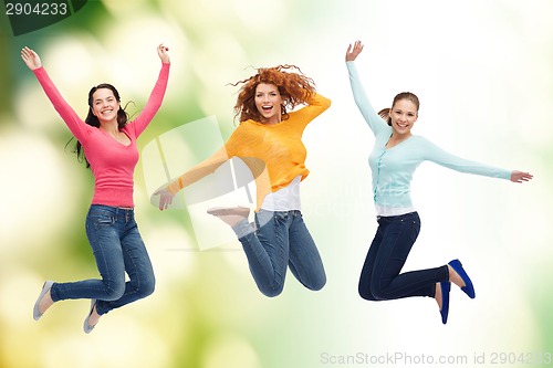 Image of group of smiling young women jumping in air