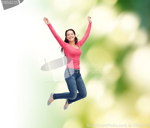 Image of smiling young woman jumping in air