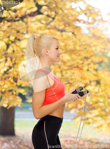 Image of smiling sporty woman with skipping rope