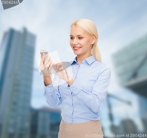 Image of young smiling businesswoman with smartphone