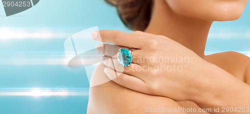 Image of closeup of woman hand with big blue cocktail ring