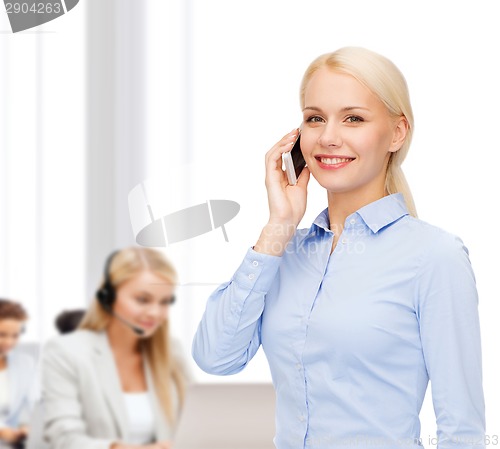 Image of young smiling businesswoman with smartphone