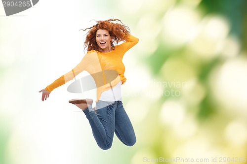 Image of smiling young woman jumping in air