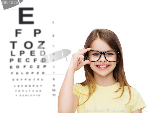 Image of smiling cute little girl in black eyeglasses