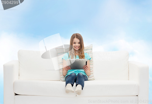 Image of little girl sitting on sofa with tablet pc