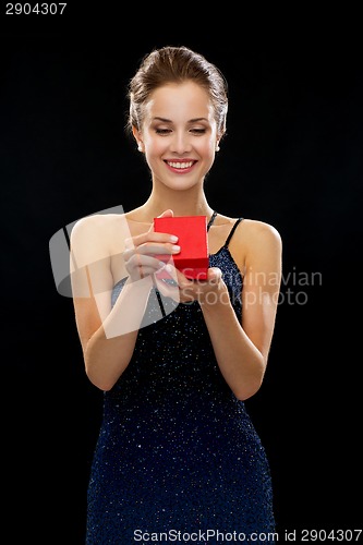 Image of smiling woman holding red gift box