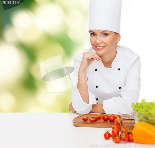 Image of smiling female chef with vegetables