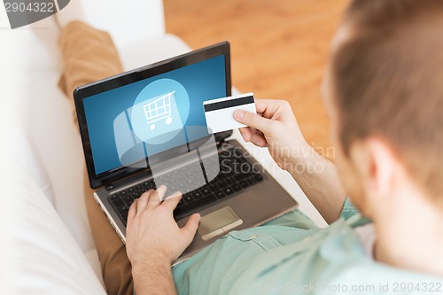 Image of close up of man with laptop and credit card