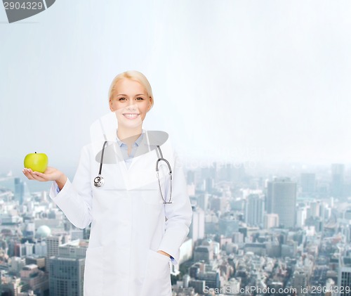 Image of smiling female doctor with green apple