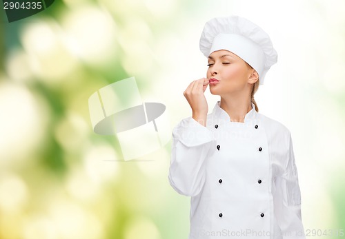Image of smiling female chef showing delicious sign