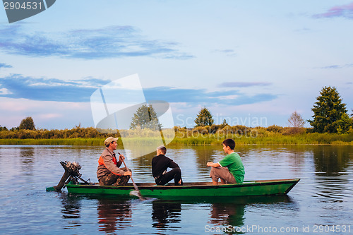 Image of Belarusian Man And Two Boys Sailing In Old Boat On River At Suns