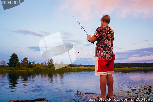 Image of Belarusian Boy Fishing From Old Boats At Sunset Of A Summer Day