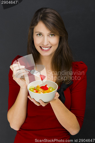 Image of Woman eating a fruit salad