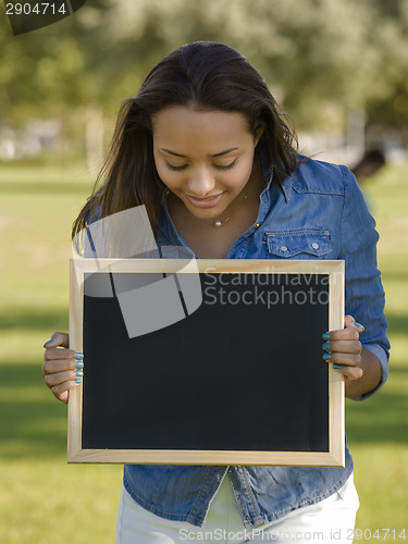 Image of Beautiful woman holding a shalkboard