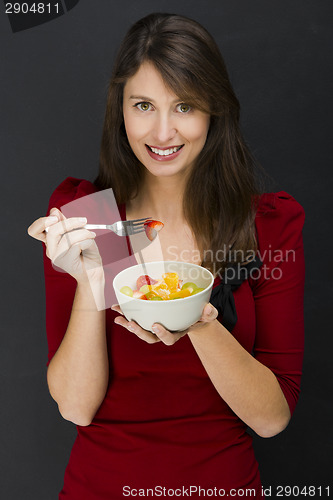 Image of Woman eating a fruit salad