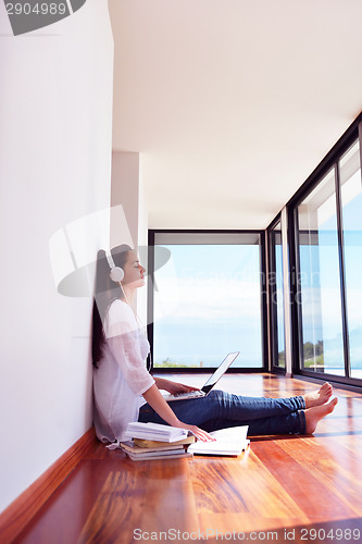 Image of relaxed young woman at home working on laptop