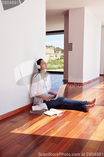 Image of relaxed young woman at home working on laptop