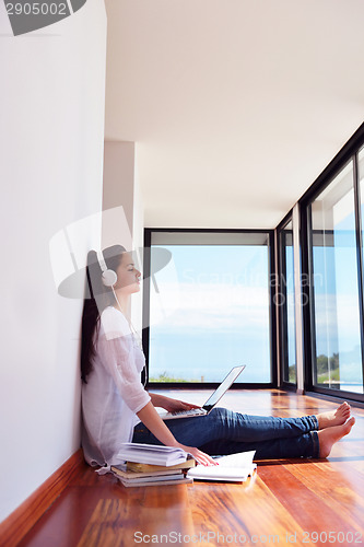 Image of relaxed young woman at home working on laptop