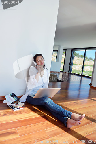 Image of relaxed young woman at home working on laptop