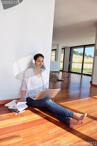 Image of relaxed young woman at home working on laptop