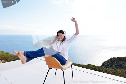Image of relaxed young woman at home working on laptop