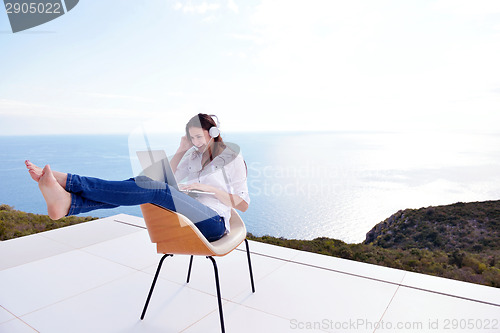 Image of relaxed young woman at home working on laptop