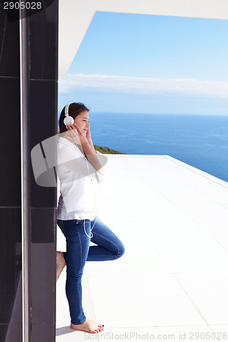 Image of girl listening to the music on white headphones