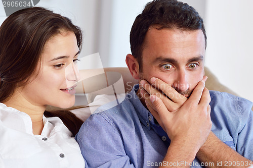 Image of relaxed young couple working on laptop computer at home