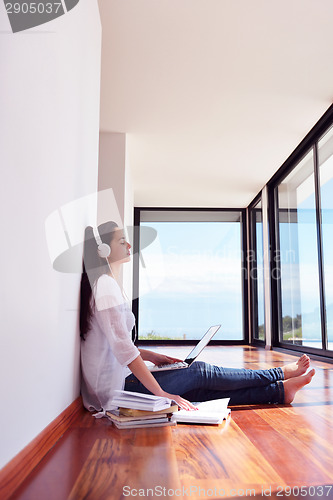 Image of relaxed young woman at home working on laptop