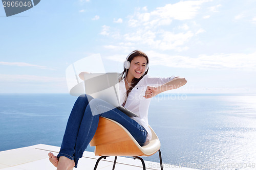 Image of relaxed young woman at home working on laptop