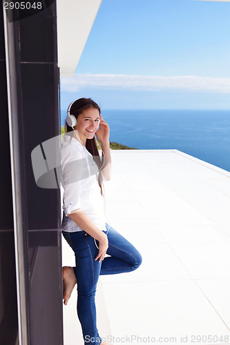 Image of girl listening to the music on white headphones